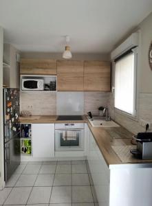 a kitchen with a sink and a microwave at Appartement avec terrasse proche gare RER in Moissy-Cramayel