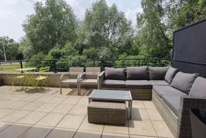 a patio with a couch and a table on a balcony at Appartement avec terrasse proche gare RER in Moissy-Cramayel