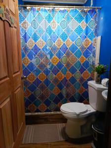 een badkamer met een toilet en een blauwe betegelde muur bij Villa Angelo Puerto Viejo in Puerto Viejo