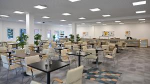 a dining room with tables and chairs at Lelle Hotel in Balatonlelle