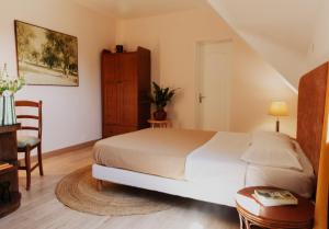 a bedroom with a bed and a table and a chair at Domaine Foray in Villecien