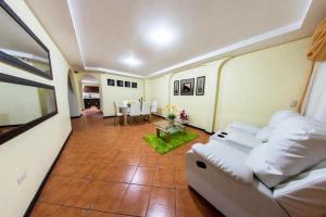 a living room with a white couch and a table at Nancy House in Alajuela City