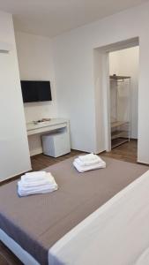 a room with two beds and a desk and a television at Fly Napoli in Naples