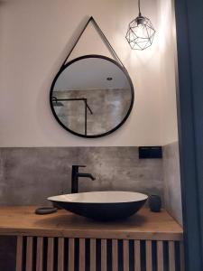 a bathroom with a large round mirror and a sink at Żuraw i Czapla in Lubkowo +30 photos