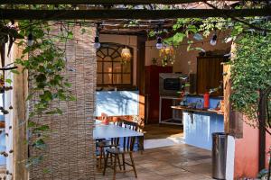 a patio with a table and a kitchen with a table and chairs at Com Verso e Prosa RePouso - SIMPLES e charmosa a poucos passos do centro histórico in Paraty