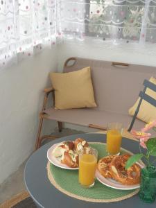 a table with two plates of food and two glasses of orange juice at Coquette Maison, Côté Château à Mutzig en Alsace in Mutzig