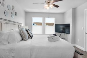 a white bedroom with a bed and a ceiling fan at Cross Breeze-Gulf Brz-Navarre, Beaches, Boat Ramp in Gulf Breeze