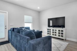 a living room with a blue couch and a flat screen tv at Cross Breeze-Gulf Brz-Navarre, Beaches, Boat Ramp in Gulf Breeze