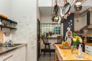 a kitchen with a counter with a sink and a table at The Haven Hostel in Thunder Bay