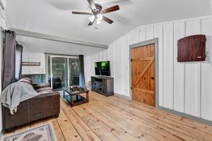 a living room with a couch and a ceiling fan at Rustic Barn Retreat in Knoxville