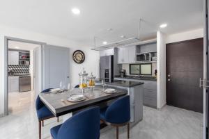 a kitchen with a dining table and blue chairs at Cabo Cove 408 in Cabo San Lucas