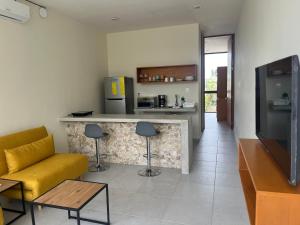 a living room with a yellow couch and a counter at Casa Itzae Hotel Boutique in Mérida