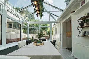 a conservatory dining room with a table and chairs at Carden Villa 4 Bedroom House With Hot Tub Pet Friendly in Brighton & Hove