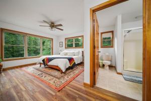a bedroom with a bed and a bathroom at Firefly Lodge! Boardman River! Hot Tub! Woodstove! in Traverse City