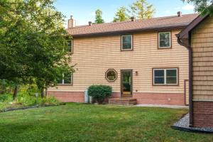 a house with a lawn in front of it at Firefly Lodge! Boardman River! Hot Tub! Woodstove! in Traverse City