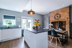 a kitchen with a fireplace and a table with chairs at NEW! 3-Bed Spacious Home in Manchester by 53 Degrees Property, Ideal for Groups, FREE Parking! in Manchester