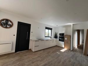 a kitchen with white cabinets and a black door at Maison neuve 4 chambre avec jacuzzi in Les-Pennes-Mirabeau