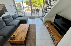 un salon avec un canapé et une télévision à écran plat dans l'établissement L'appart B42, à Gruissan