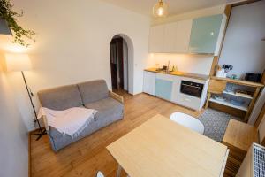a living room with a couch and a kitchen at Au petit mouton in Fernelmont