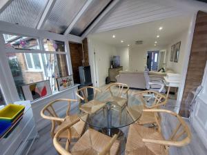 einen Glastisch und Stühle im Wohnzimmer in der Unterkunft Luxurious 3 Bedroom House in Kent + 33 Fotos