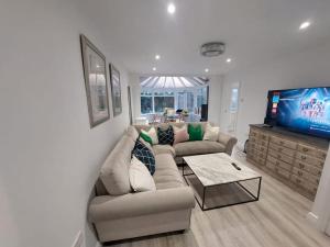 ein Wohnzimmer mit Sofa und Fernseher in der Unterkunft Luxurious 3 Bedroom House in Kent