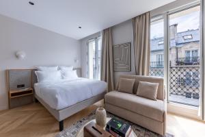 une chambre avec un lit, un canapé et une fenêtre dans l'établissement Quartier Libre Marais, à Paris