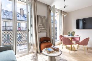 un salon avec une table et des chaises et un balcon dans l'établissement Quartier Libre Marais, à Paris