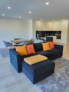 ein Wohnzimmer mit einer blauen Couch mit bunten Kissen in der Unterkunft Loreto House in Bragança