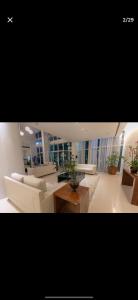a living room with white furniture and potted plants at Flat Hotel Saint Moritz ap 2008 in Brasilia