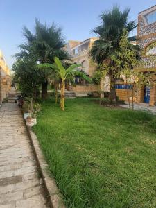 a yard with palm trees and a brick building at Beachhouse Asilah in Asilah