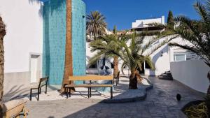 a bench and palm trees in front of a building at Gaviotas Beach Golf in Almerimar