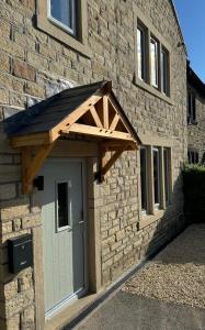 a wooden entry door to a stone building at Haworth Holiday Home in Haworth