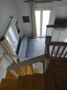 a staircase with a couch and a television in a room at Lionaki House in Skopelos Town