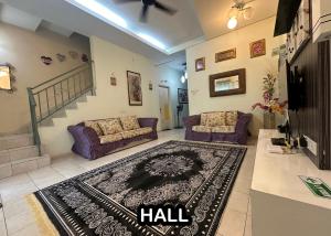 a living room with two couches and a rug at Tamu House Botani in Ipoh