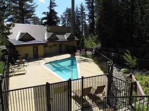 a house with a swimming pool next to a fence at Courchevel #15 - 2 Bedroom, 2 Bathroom, Sleeps 6! Just steps to Canyon Lodge! in Mammoth Lakes