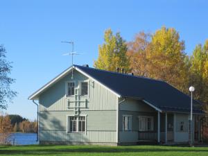 a large white barn with a black roof at Naapurivaaran Lomakeskus in Vuokatti