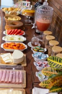 a table topped with lots of different types of food at Pousada Bem Viver - Charme e Conforto in Nobres