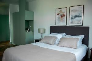 een slaapkamer met een groot wit bed met twee kussens bij Casa de Campo Franco da Serra in Angra do Heroísmo