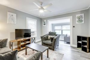 ein Wohnzimmer mit einem Fernseher und zwei Stühlen und einem Tisch in der Unterkunft Easthampton Apartment Near Breweries and Rail Trail! in Easthampton