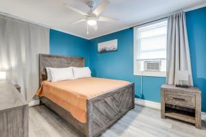 ein blaues Schlafzimmer mit einem Bett und einem Fenster in der Unterkunft Easthampton Apartment Near Breweries and Rail Trail! in Easthampton