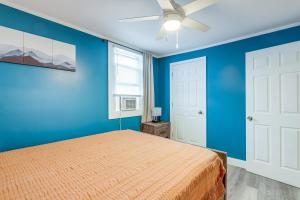 ein blaues Schlafzimmer mit einem Bett und einem Deckenventilator in der Unterkunft Easthampton Apartment Near Breweries and Rail Trail! in Easthampton