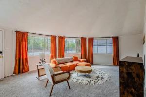 a living room with an orange couch and a table at Groovy Getaway with Fenced Yard in Augusta +12 photos