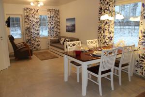 a dining room and living room with a table and chairs at Lapland Koivusto Apartment in Ranua