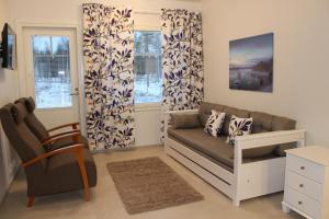- un salon avec un canapé et une chaise dans l'établissement Lapland Koivusto Apartment, à Ranua
