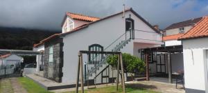 a white building with a staircase in a yard at Casas do Baleeiro - Vivenda do Terras in São Roque do Pico