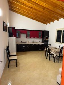 a kitchen with red cabinets and a table and chairs at Villa Cepeli in Golemasi