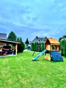 einen Spielplatz mit Rutsche und Spielstruktur in der Unterkunft Domek u podnóża Skrzycznego in Lipowa + 9 Fotos