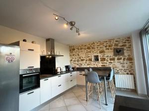 Nohant-VicにあるMaison berrichonne authentique avec jardin, près du Domaine de George Sand et activités variées - FR-1-591-195の石壁のキッチン(白いキャビネット付)