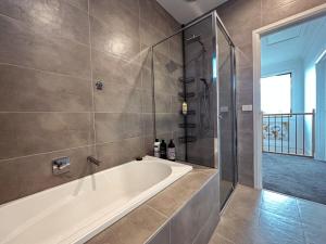 a bathroom with a tub and a glass shower at Luxury Glen Waverley Townhouse 4br3ba Backyard in Glen Waverley +37 photos