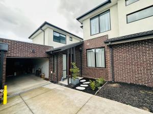a brick house with a garage and a driveway at Luxury Glen Waverley Townhouse 4br3ba Backyard in Glen Waverley